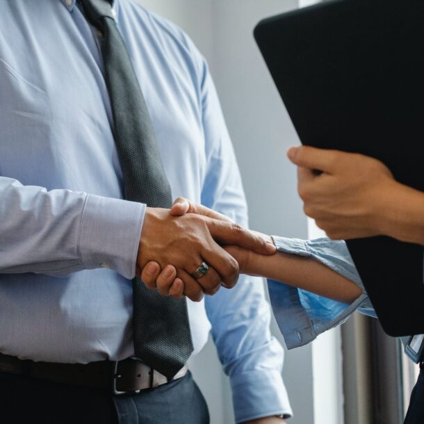 man and woman shaking hands in office
